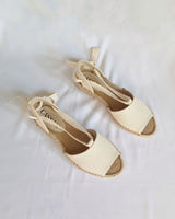 Alpargatas planas textil crudo atadas con cintas al tobillo