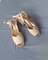 Alpargatas planas textil crudo atadas con cintas al tobillo