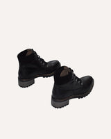 Botines militares con suela track en piel negra, con detalle en serraje negro en la parte del tobillo para mayor comodidad.