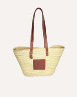 Capazo de palmaa natural y asas ajustables en piel color marrón. Cassani made in Spain.