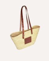 Capazo de palmaa natural y asas ajustables en piel color marrón. Cassani made in Spain.