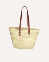 Capazo de palmaa natural y asas ajustables en piel color marrón. Cassani made in Spain.