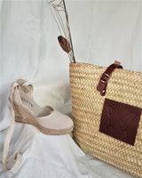 Capazo de palmaa natural y asas ajustables en piel color marrón. Cassani made in Spain.