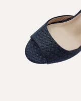 Sandalias en piel trenzada negra atadas al tobillo con hebilla cuadrada y tacón ancho de 7,5 cm.