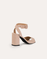 Sandalias en ante beige atadas al tobillo con hebilla cuadrada y tacón ancho de 7,5 cm.