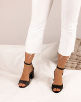 Sandalias en piel trenzada negra atadas al tobillo con hebilla cuadrada y tacón ancho