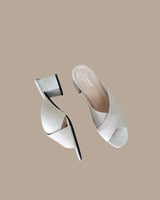 Sandalias mules de piel en ante color crudo con pala cruzada y tacón cuadrado de 4,5 cm. Cassani Made in Spain