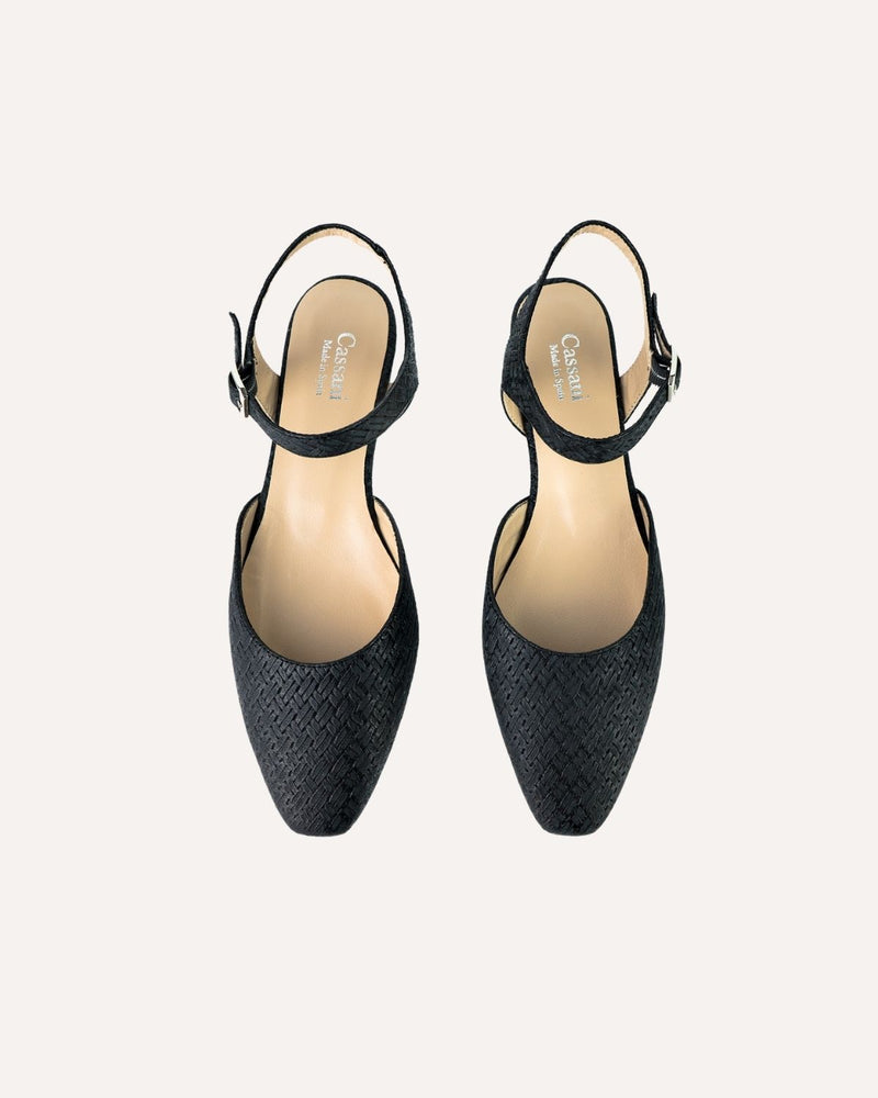 Zapatos planos tipo bailarinas atados al tobillo en piel trenzada color negro. Punta alargada con terminación cuadrada. 