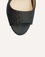 Sandalias en piel trenzada negra atadas al tobillo con hebilla cuadrada y tacón ancho de 7,5 cm.